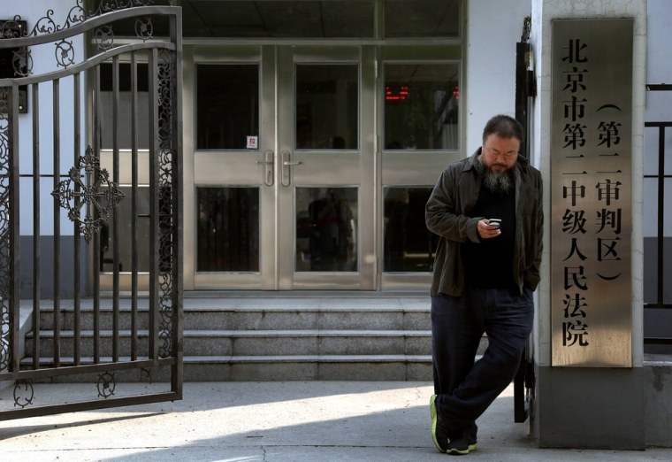 Dissident Chinese artist Ai Weiwei waits outside the entrance of the Chaoyang District Court before attempting to attend his appeal verdict hearing in Beijing on September 27, 2012.