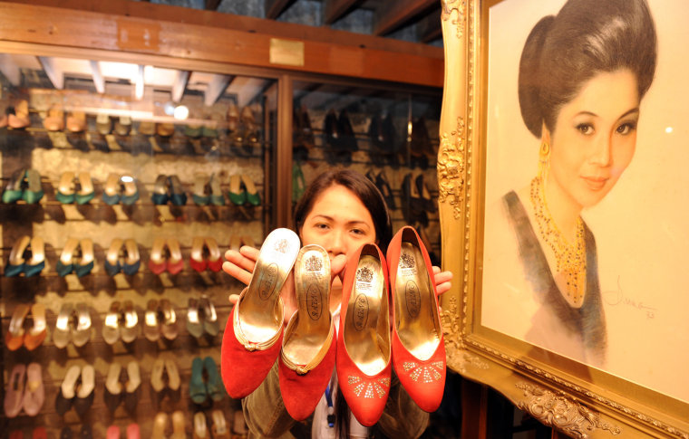 A museum employee displays some of the shoes of former Philippine first lady Imelda Marcos, next to her portrait at the shoe museum in Manila on Wednesday.