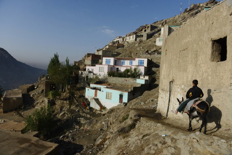 A young resident of the hillside neighborhood of Jamal Mina rides a donkey down to a water collection point high above Kabul on Sept. 27.