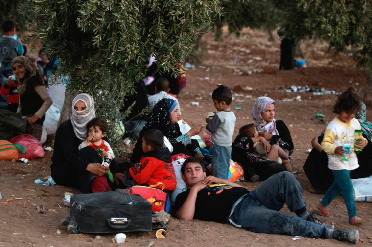 Syrian refugees fleeing violence in their country take a break after they crossed into Jordanian territory with their families from Syria into Jordan, near the town of Ramtha on Sept. 15.
