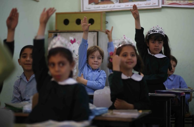 Palestinian school children raise their hands during a class in al-Qahera elementary school in Gaza City on April 2. New rules from the Education Ministry of the Islamist Hamas movement ruling the Gaza Strip will bar men from teaching at girls' schools and mandate separate classes for boys and girls from the age of nine.
