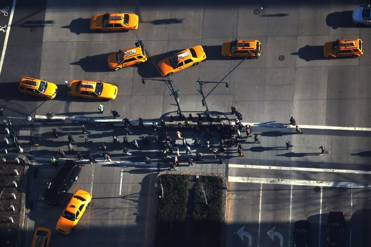 Pedestrians cross the street in lower Manhattan as seen from One World Observatory on the 100th floor of One World Trade Center at the Ground Zero site on April 2, in New York City.