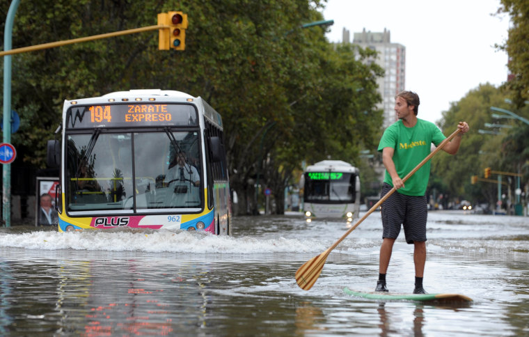 A man rides a paddleboard after heavy rains lashed Buenos Aires, Argentina, on April 2.