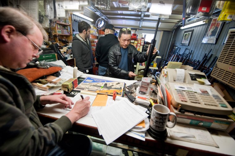 Vic Benson, owner of The Freedom Shoppe, records the sale of an assault weapon during a sale in anticipation of new gun control measures in New Milford, Conn., April 2, 2013.