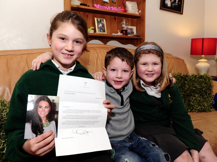 A trio of youngsters (from left, Isabella Clarkson, 10, Reuben Clarkson 4 and Alice Clarkson, 8) smile with delight after receiving a letter on behalf of the Duchess of Cambridge Kate Middleton.