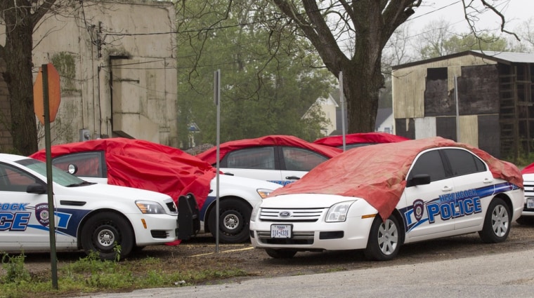 Several Hitchcock Police cars sit under tarps after they were damaged by the hail storm on Wednesday,