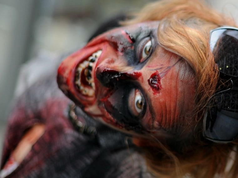 An actress portraying a zombie poses for a picture to promote