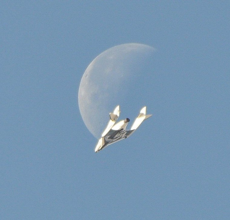 A waning moon serves as a backdrop for Virgin Galactic's SpaceShipTwo as the rocket plane glides through a test flight on Wednesday over the Mojave Air and Space Port in California.