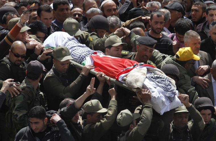 Palestinian security forces carry the body of Maysara Abu Hamdiyeh, center, during his funeral in the West Bank city of Hebron on Thursday, April 4, 2013.