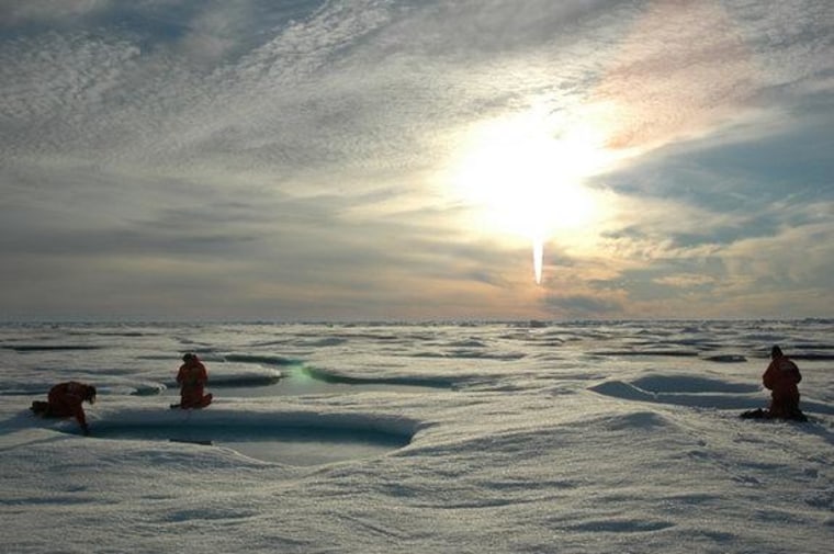 Scientists work on the ice in the Arctic under a midnight sun.