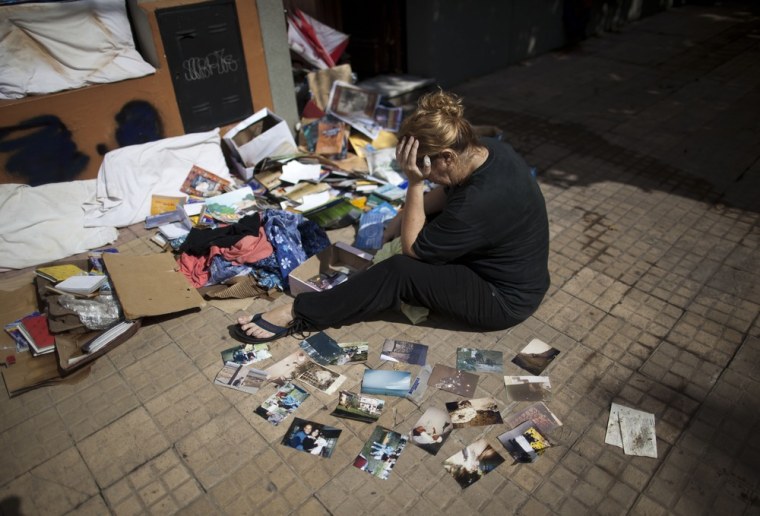 Vilma Gorostiaga cries outside her home as she dries her family pictures on the ground in La Plata, in Argentina's Buenos Aires province, on April 4.