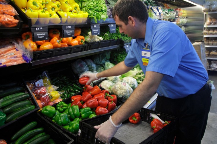 A worker stocks produce at a Walmart Express store in Chicago on July 26, 2011.