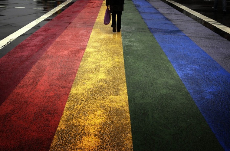 A pedestrian walks across a rainbow pedestrian crossing painted on Sydney's Oxford Street, the city's main gay district, on April 4, 2013.