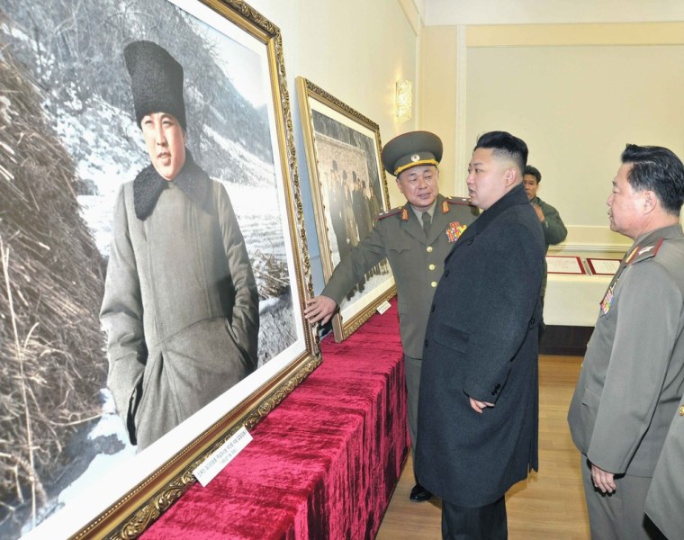 Kim Jong Un looking looks at a photo of his grandfather Kim Il Sung last month.