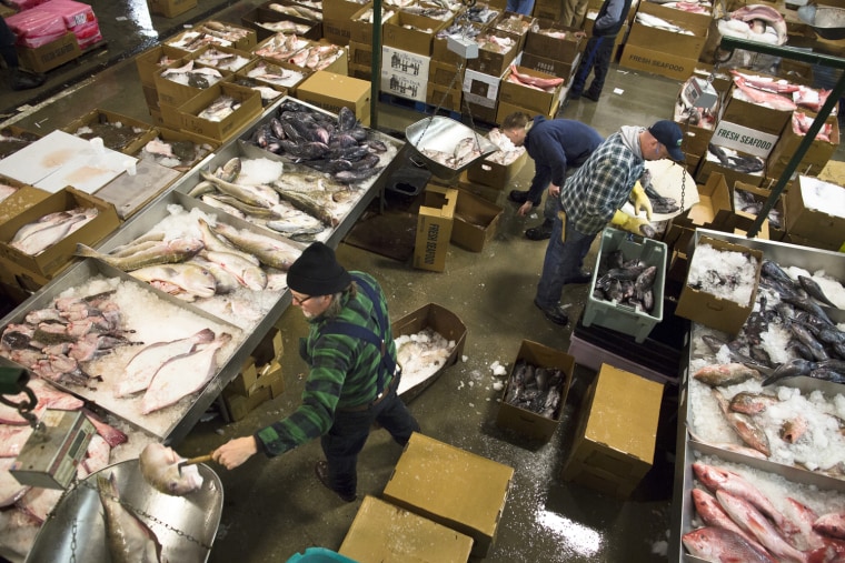 Fishmongers ply their trade on the floor of the Fulton Fish Market, on March 29, 2013, in New York.
