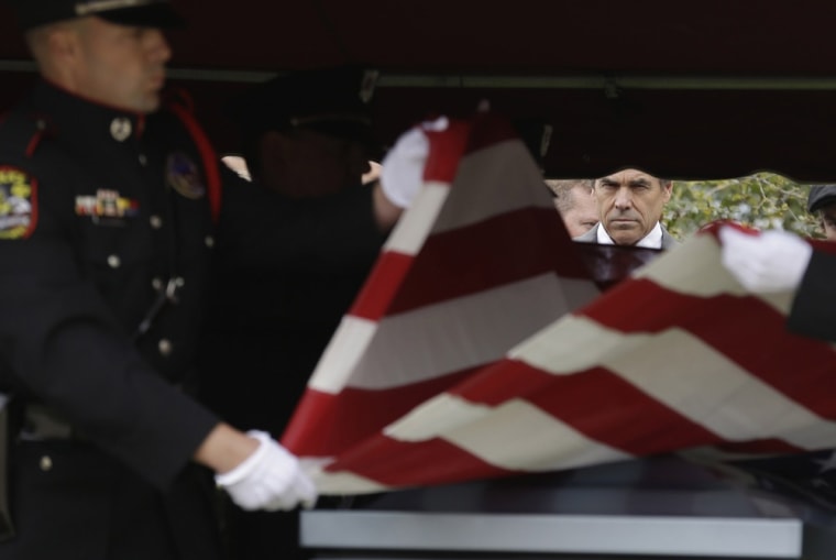 Texas Gov. Rick Perry looks on as a flag is folded to present to the family of Kaufman County District Attorney Mike McLelland and his wife, Cynthia after a memorial services in Mesquite, Texas on April 4.