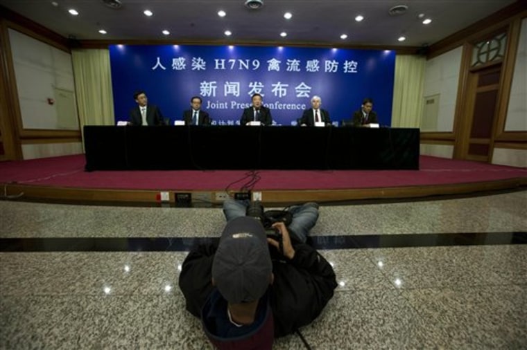 A photographer takes a photo of a joint press conference by Chinese health officials and World Health Organization representatives, from left, Deng Haihua, spokesman for China's Commission of Health and Family Planning, Feng Zhijian, head of the emergency office of China's Disease Control and Prevention Center or CDC,  Liang Wannian head of a Chinese government office in charge of H7N9 bird flu prevention control, Michael O'Leary, head of the WHO's office in China, and Sirenda Vong, the WHO's Emerging Infectious Diseases expert,  in Beijing, China, Monday, April 8, 2013. The World Health Organization is talking with the Chinese government about sending international experts to China to help investigate a new bird flu strain that has killed six. Most of the 21 people stricken so far got severely ill.   (AP Photo/Ng Han Guan)
