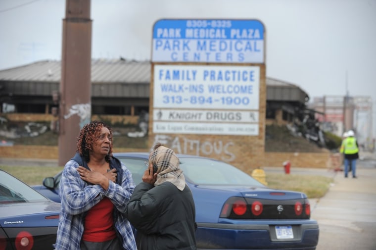 Bystanders react after shots were fired inside the at the Park Medical Plaza office building in Detroit and the structure was set ablaze on Tuesday.