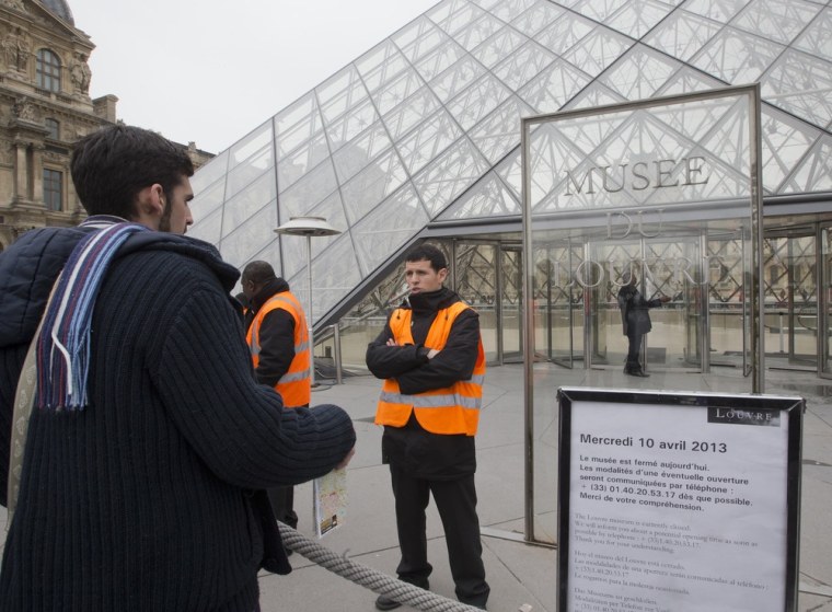 A visitor stands in front of the closed Louvre museum Paris, France, Wednesday.