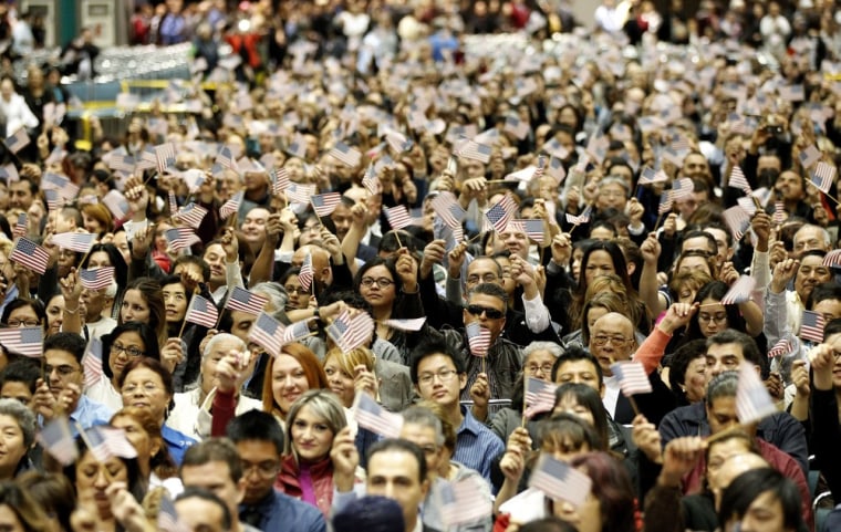 Candidates wave U.S. flags during a naturalization ceremony to become citizens in Los Angeles in February.