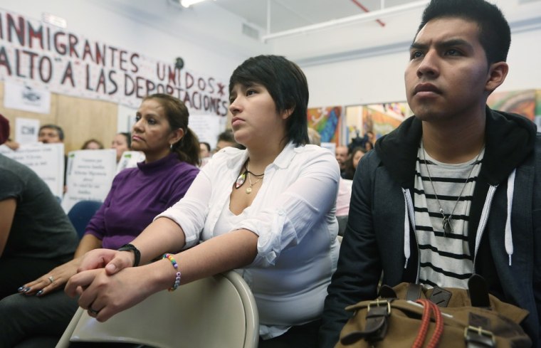 Undocumented immigrant Oscar Rodriguez, right, originally from Mexico, watches with Yenny Quispe, center, who is from Peru and recently received her Green Card, during a watch party for President Barack Obama's speech on immigration on Jan. 29, 2013 in New York City.