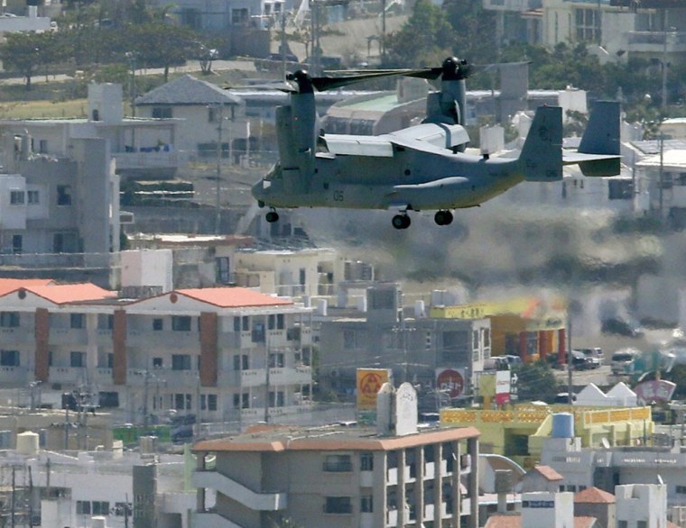A Marine Corps Osprey aircraft flies to land at Futenma air base in crowded Ginowan, Okinawa. City residents are angry about the base, but many residents of the town of Henoko, where a new base is planned to replace it, are angry as well.
