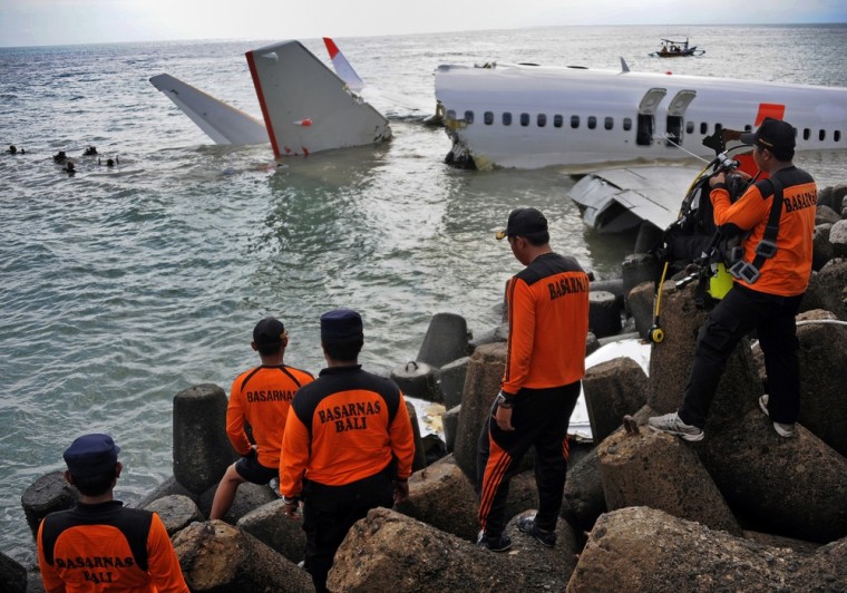 Members of a rescue team watch as divers prepare to retrieve the black box from a partially submerged Lion Air Boeing 737 on April 15, 2013, two days after it crashed while trying to land at Bali's international airport near Denpasar. The pilot and co-pilot of a Lion Air plane that crashed at Bali's airport have passed initial drug tests, an official said on April 15, as investigators probe the causes of the accident that left dozens injured but no fatalities.