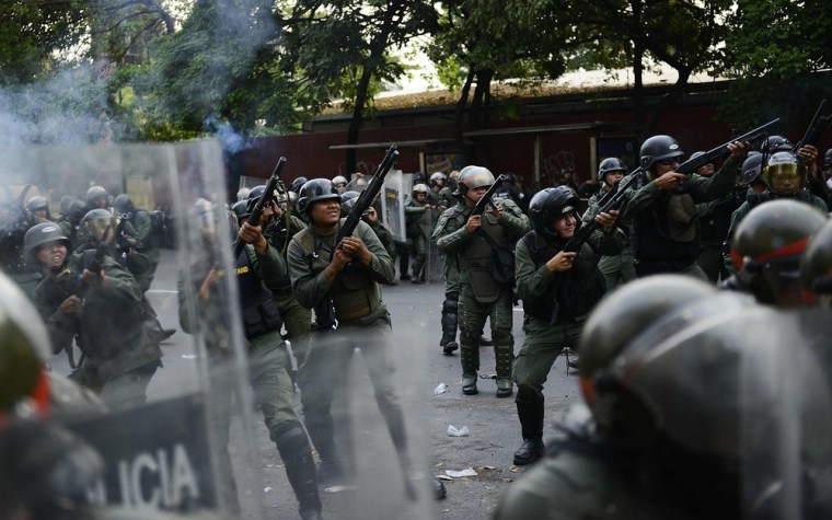 Riot police with tear gas face off against opposition supporters in Caracas on April 15, 2013. Venezuela's acting president, Nicolas Maduro, was proclaimed the winner of the country's election on Monday, triggering protests as the opposition demanded a recount.