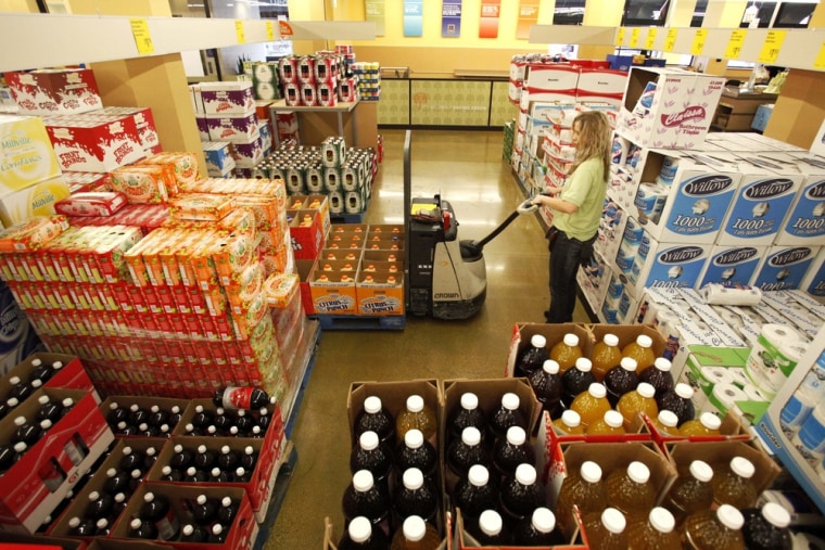 In this photo taken Oct. 13, 2010, cashier Ciara Helton stocks the aisle at the Aldi grocery store in Chicago. Nearly nine in 10 consumers are substituting private-label, or store, brands for national brands, according to a new survey.