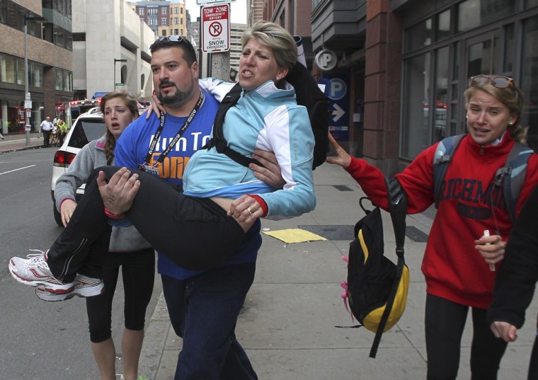 A woman is carried from the scene on Exeter Street after two explosions went off on Boylston Street near the finish line of the 117th Boston Marathon on April 15, 2013.