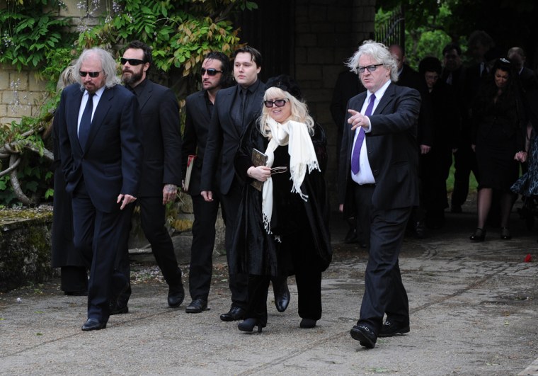 Barry Gibb, Robin's son, Robin-John Gibb, and Robin's widow, Dwina Murphy Gibb, along with other Gibb family members, arrive for Robin Gibb's funeral.