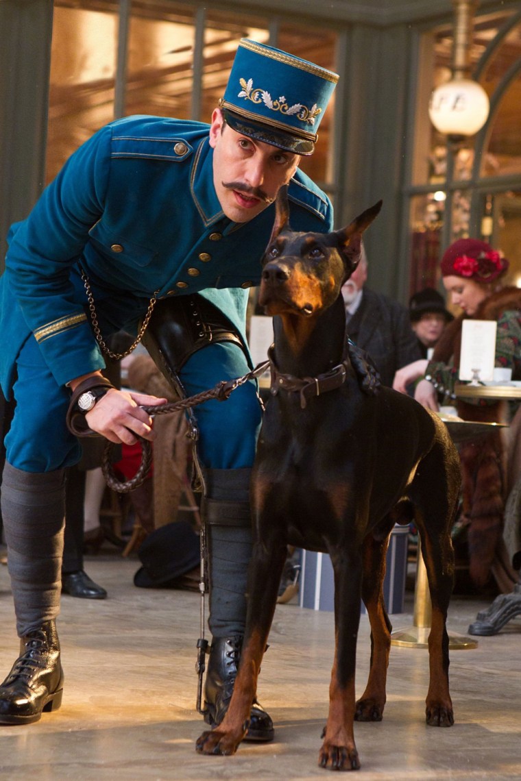 Sacha Baron Cohen as The Station Inspector with Blackie in \"Hugo.\"