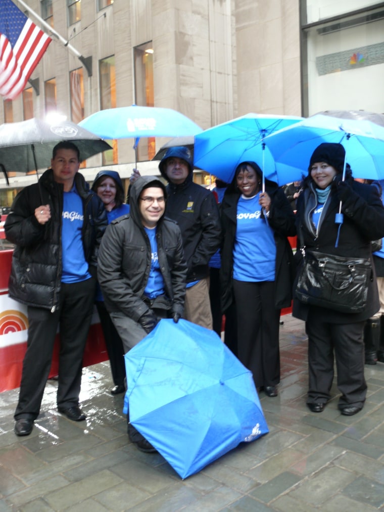 GOYA Gives Volunteers face the rain this morning to promote hunger awareness and healthy eating habits.