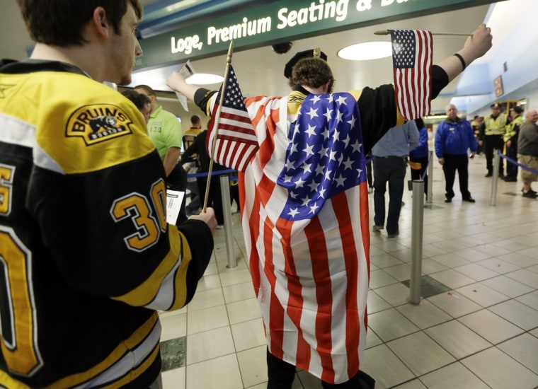 A fan wearing a United States flag raises his arms to be checked on the way into TD Garden prior to the game.