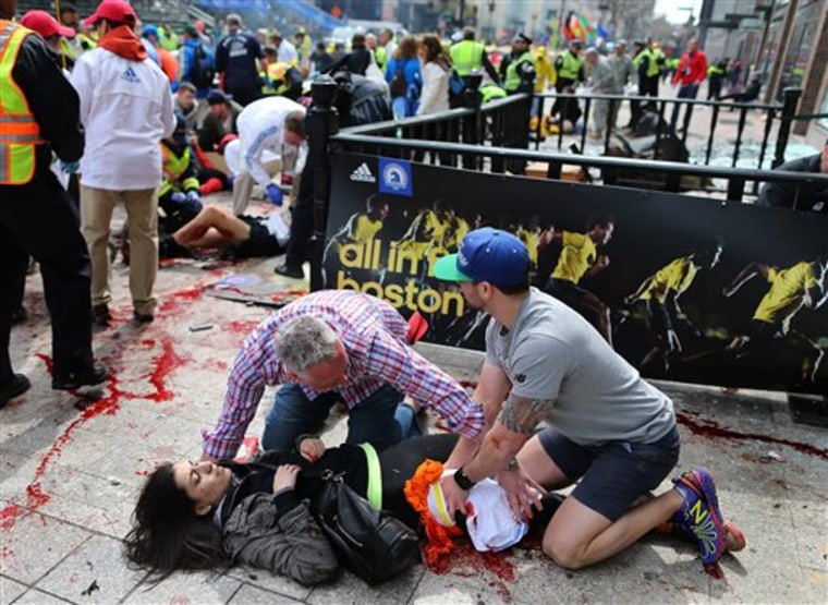 Sydney Corcoran, of Lowell, Mass. is tended to at the finish line of the Boston Marathon after two bombs exploded, in Boston. .