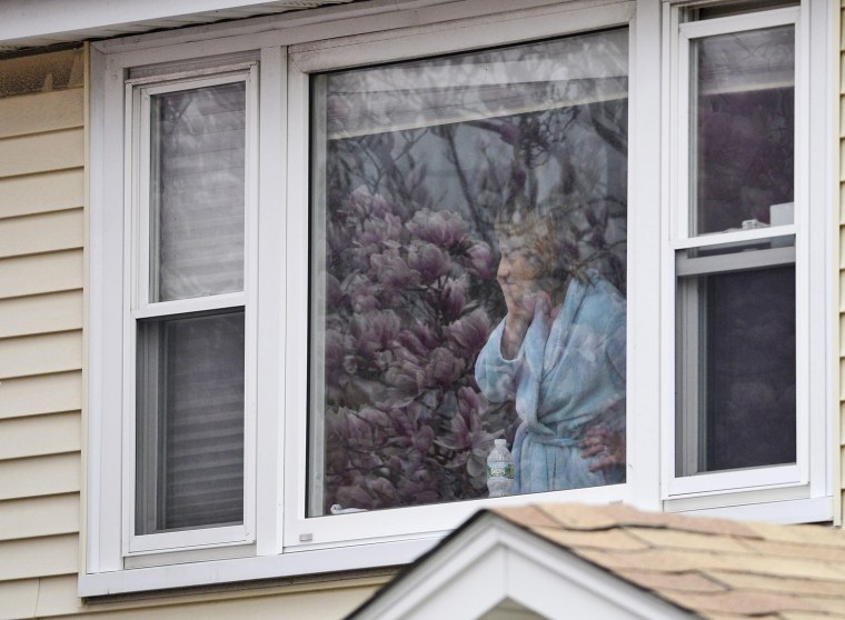 A resident watches as police search an apartment complex in Watertown, Mass., on April 19.