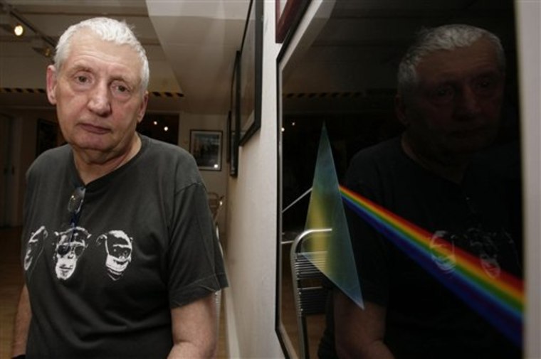 Storm Thorgerson stands next to his album cover artwork for Pink Floyd's \"The Dark Side of the Moon\" at a 2008 art exhibit.