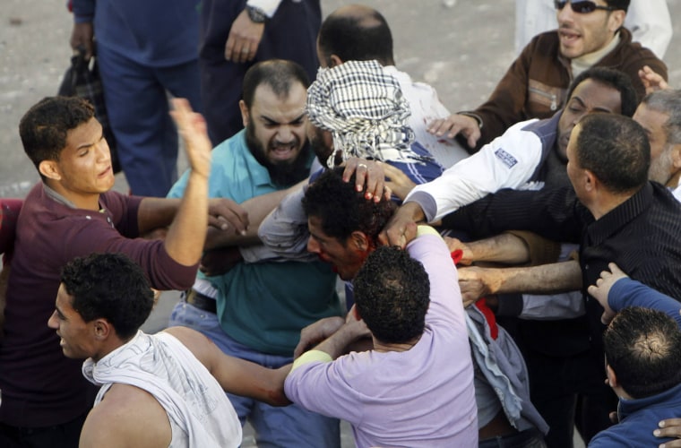 Muslim Brotherhood members hit an anti-government protester during clashes near Cairo's Tahrir Square, April 19.