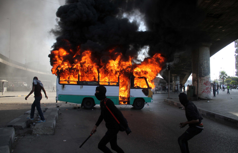 Egyptian protesters clash near a bus belonging to Muslim Brotherhood supporters burns after it was reportedly set alight by anti- government protesters in Cairo, Egypt, Friday, April 19.