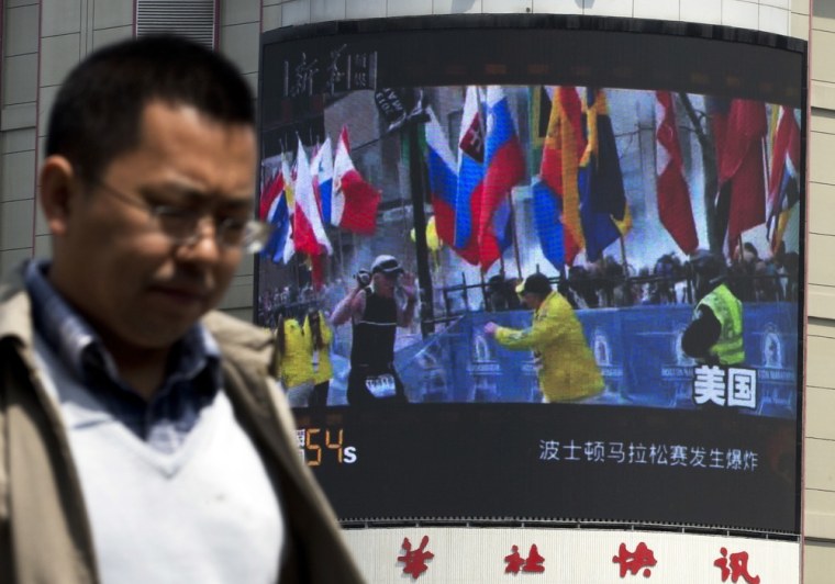 A Chinese man walks past a huge screen which reports Boston Marathon bombings that killed three and wounded more than 170 people, in Beijing, China Wednesday, April 17, 2013. A state-run Chinese newspaper says the third person killed in the Boston Marathon bombings is a Chinese graduate student at Boston University originally from China's northeastern city of Shenyang. (AP Photo/Andy Wong)