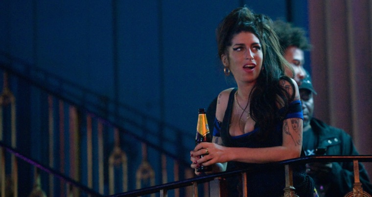Amy Winehouse drinks a beer as she watches The Libertines perform in London last August.