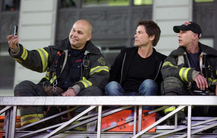 Rob Lowe, center, poses with firefighters atop a ladder truck as people celebrate after Al Qaeda leader Osama bin Laden was killed in Pakistan, during a spontaneous celebration in New York's Times Square on May 1.