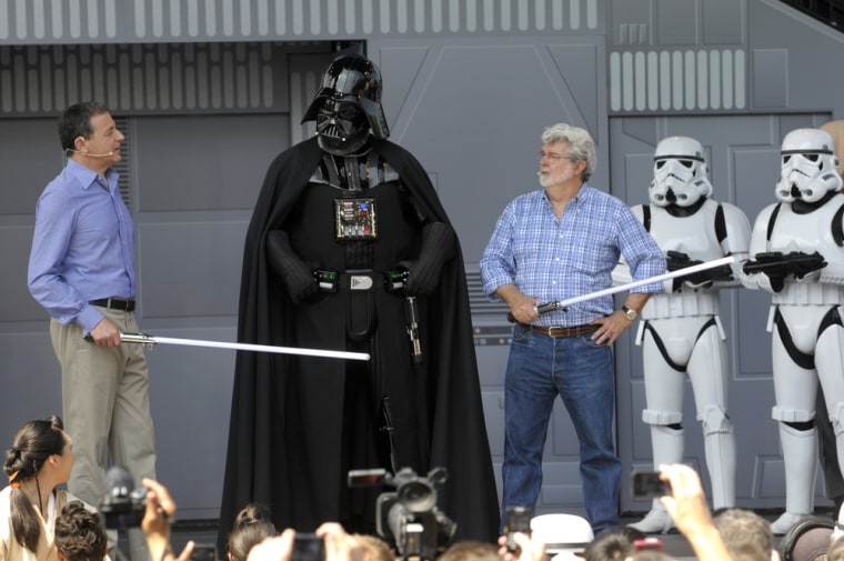 \"Star Wars\" creator George Lucas, right, joins Disney CEO Robert Iger, left, during the reopening celebration of the \"Star Tours\" motion simulation ride at the Disney Hollywood Studios theme park in Lake Buena Vista, Fla., Friday, May 20.