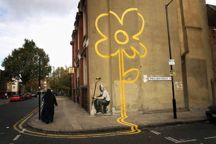 A woman walks past a piece by self-styled guerilla artist Banksy in London in November.