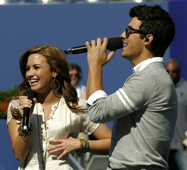 Joe Jonas, right, and Demi Lovato warm up during an event at the USTA Billie Jean King National Tennis Center in Flushing, N.Y., on Aug. 28.