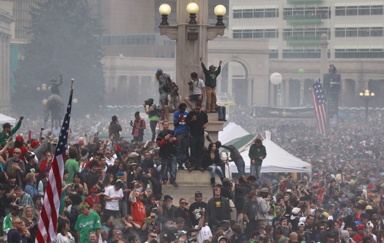 Members of a crowd numbering tens of thousands smoke marijuana and listen to live music, at the Denver 420 pro-marijuana rally at Civic Center Park in Denver on Saturday, April 20, 2013.