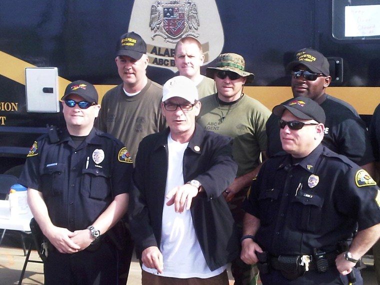 Charlie Sheen poses with police officers and National Guard soldiers in Tuscaloosa, Ala., on Monday.