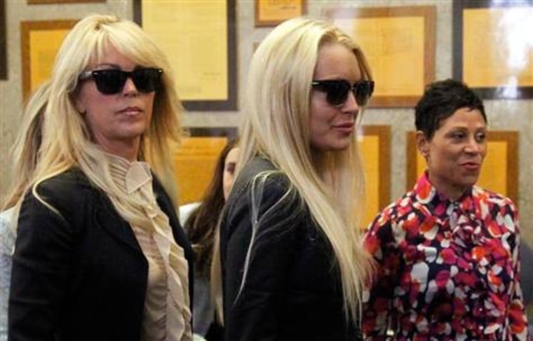Lindsay Lohan, center, enters the Beverly Hills Municipal Courthouse with her mom Dina Lohan, left, on July 20. \"Her parents need plenty of behavioral work,\" one addiction specialist said.