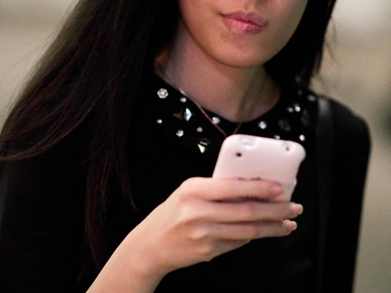 A woman checks her smartphone in this file image.