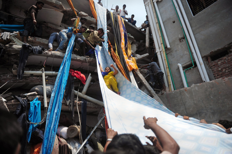 Bangladeshi garment workers help evacuate a survivor using rolls of fabric as a slide to evacuate people from the rubble after the building collapsed in Savar, Bangladesh on April 24.